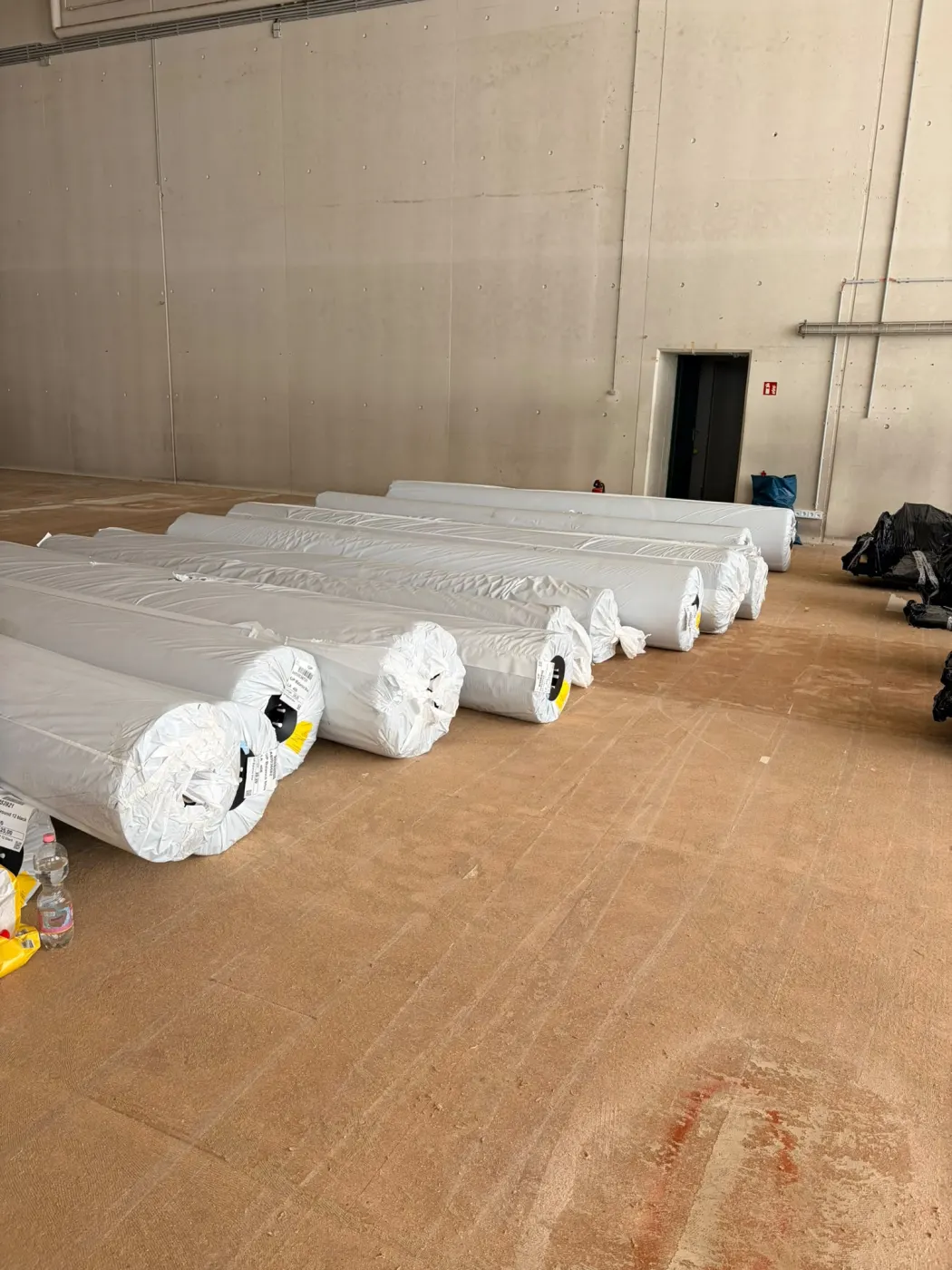Weiß verpackte Materialrollen in der leeren Halle